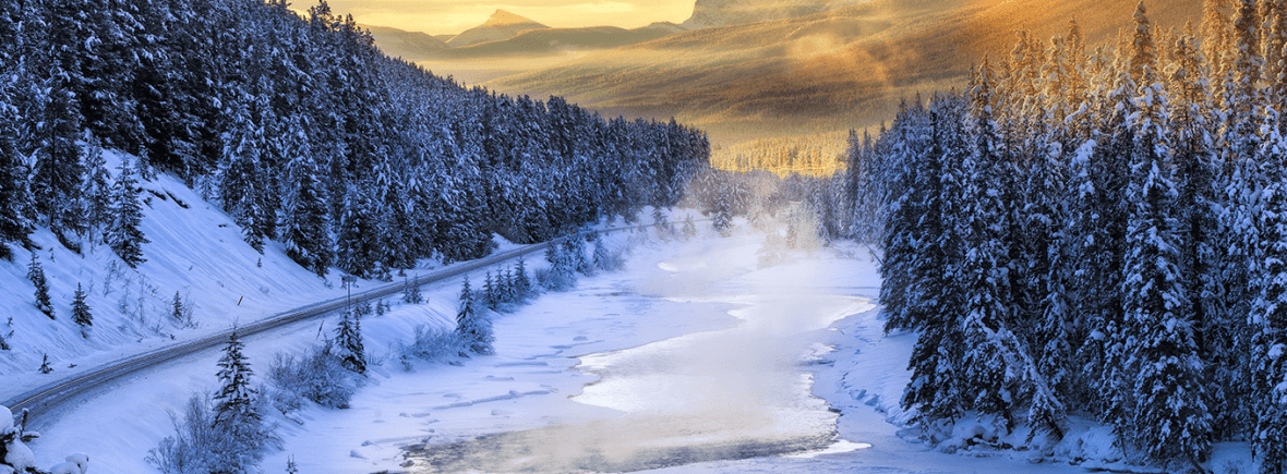 Image of river in the mountains, surrounded by pine trees during winter